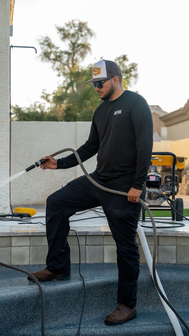 Pool service cost outside the monthly plan: a Stay Fresh Pools technician pressure washing the steps of a drained pool in the East Valley, Arizona